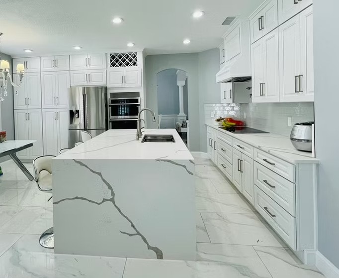 Glacier White kitchen with calacatta quartz island, floor-to-ceiling cabinets and white porcelain floor