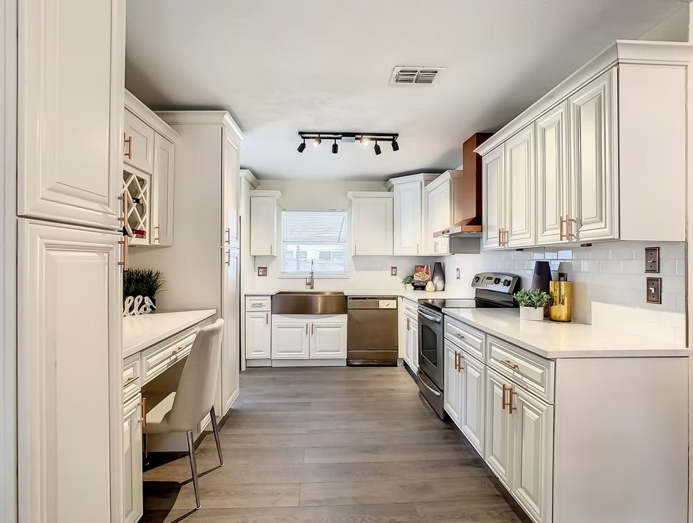 Full view of Pearl White kitchen with copper hood and stainless steel appliances