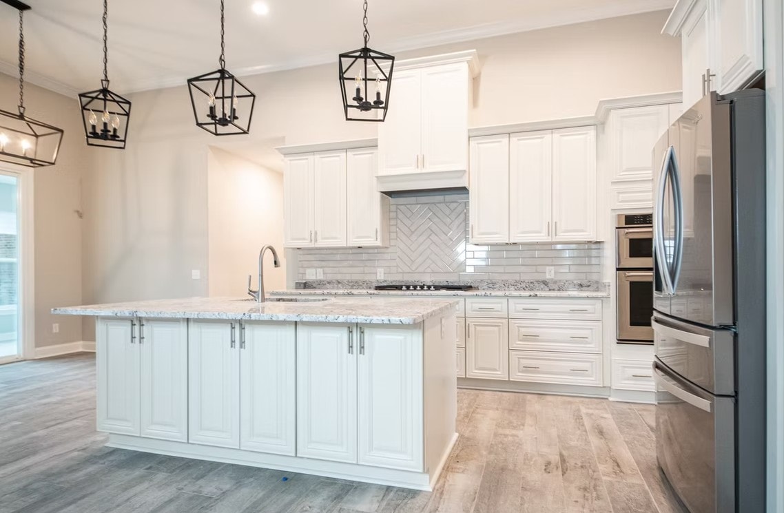 Pearl White kitchen with large island, black pendant lights and herringbone backsplash