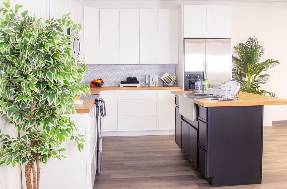 Side view of Slim Shaker Alabaster kitchen with black island and tropical plants