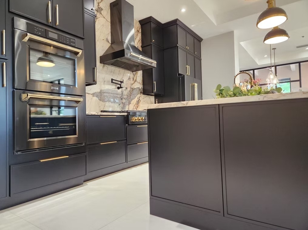 Detail of Slim Shaker Ebony cabinets with gold hardware and stainless steel hood